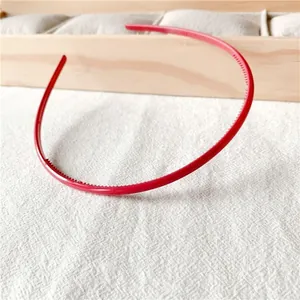 Close-up of red candy-colored headband featuring non-slip inner teeth for hair styling