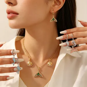 Detailansicht eines Ozean-Schmucksets mit Delfin- und Muschelanhängern an einem Modell