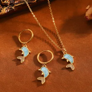 Detail des goldenen Delphin-Schmucksets mit blauem Muschelinlay und Strasssteinen.