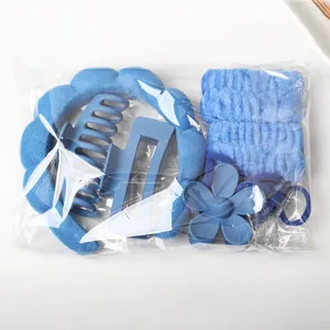 Blue spa headband and wristband set with hair clips in clear packaging for skin care