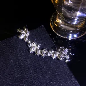 Detail of silver ear cuff with sparkling marquise stones and floral zircon design