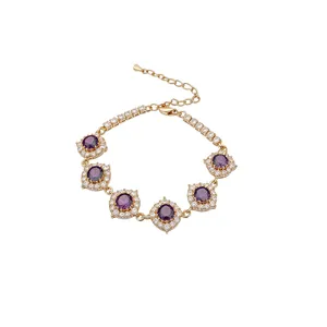 Elegante bracciale dorato con zirconi viola tondi e un design scintillante a raggio di cristalli