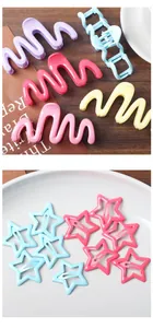 Détail de pinces à cheveux ondulées et de barrettes étoiles aux couleurs acidulées
