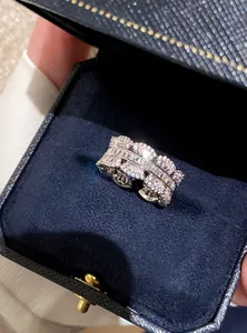 Close-up of a sparkling zircon lace open ring in a navy velvet jewelry box