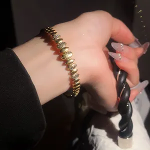 Vue macro d'un luxueux bracelet en acier inoxydable doré avec des pierres de zircon
