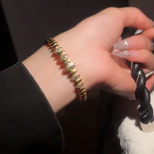 Gros plan détaillé d'un bracelet en acier doré orné de zircons étincelants