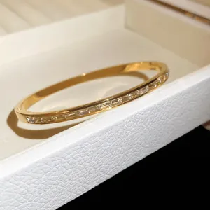 Détail macro d'un bracelet en acier doré serti de cristaux brillants de taille baguette