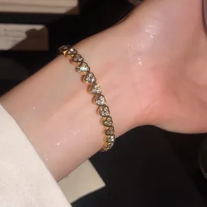 Gros plan sur les élégants maillons en cœur brillants de ce bracelet plaqué or