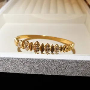 Gros plan détaillé d'un bracelet élégant en acier inoxydable doré orné de zircons.