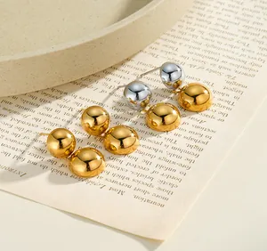 Dettaglio macro di orecchini a sfera in acciaio inossidabile oro e argento su carta vintage