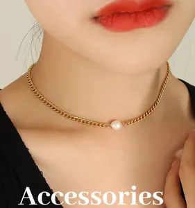 Close-up of golden Cuban chain necklace with a single white pearl on a female model