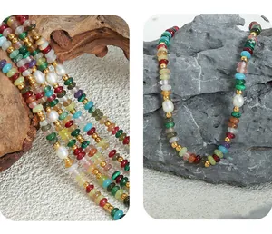 Dettaglio di perline boho colorate e perle d'acqua dolce su collana di pietra