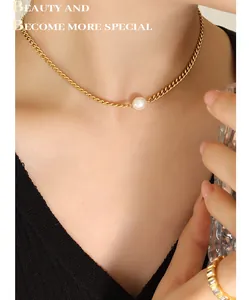 Close-up of minimalist gold titanium necklace with a single freshwater pearl on a model