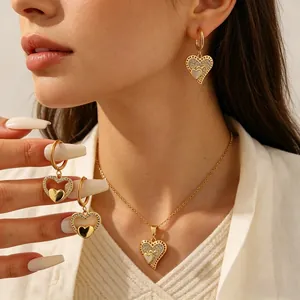 Gros plan d'un élégant ensemble collier et boucles d'oreilles cœur doré avec cristaux