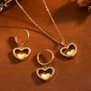 Détail de l'ensemble collier et boucles d'oreilles cœur en acier doré avec strass