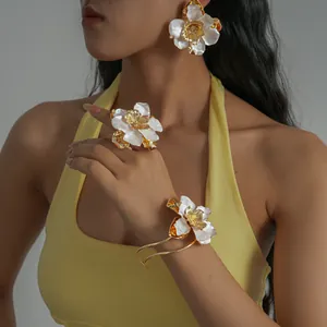 Gros plan d'un ensemble de bijoux élégants en émail blanc et or portés par un mannequin