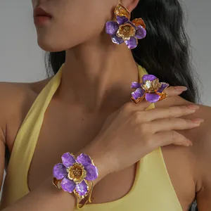 Détail d'une parure de bijoux fleurs en émail violet avec boucles d'oreilles et bague