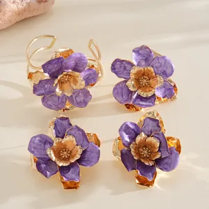 Gros plan détaillé d'une bague fleur en émail violet avec des pétales en métal doré