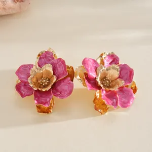 Détail d'une bague en métal doré avec un motif de fleur en émail rose pour femmes