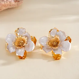 Vue détaillée de deux bagues fleurs dorées avec pétales en émail nacré et froissé