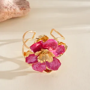 Vue détaillée de la texture de la fleur en émail rose plissée sur la bague dorée