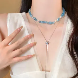 Dettaglio ravvicinato di girocollo in pietra blu abbinato a collana con stella marina