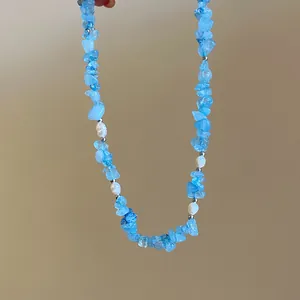 Dettaglio di una collana curativa in pietra blu con eleganti perle bianche da donna