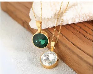 Macro detail of round emerald and crystal glass pendants on gold-plated O-chains