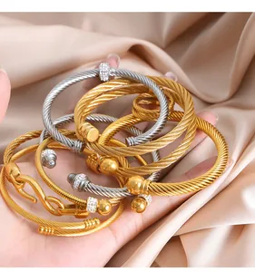 Detail of gold and silver cable bracelets with zircon accents on champagne silk