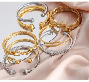 Detailed view of gold and silver twisted cable bracelets with zircon accents and textures