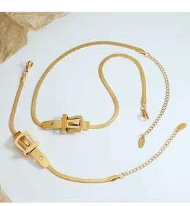 Detail view of gold snake chain necklace with buckle charms and K18 hallmark tag