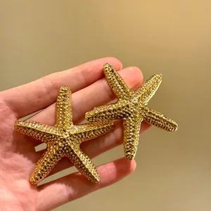 Primo piano dettagliato che mostra la superficie strutturata di questi orecchini a stella marina.