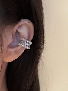 Close-up detail showing a French vintage zircon pearl ear cuff worn on a human ear