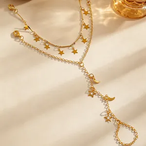Dettaglio di un elegante bracciale a due strati color oro con ciondoli a stella e luna