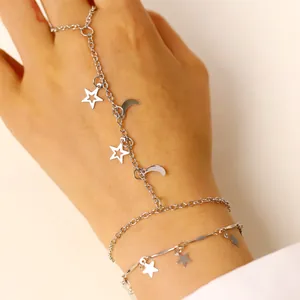 Bracciale ad anello argentato con ciondoli a stella e luna sulla mano della donna