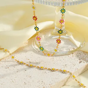 Nahaufnahme kleiner Emaille-Gänseblümchen-Anhänger an einer 18k vergoldeten Edelstahlkette.