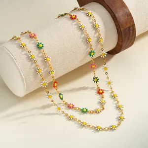 Detailansicht bunter und weißer Emaille-Gänseblümchen-Anhänger an goldenen Edelstahlketten