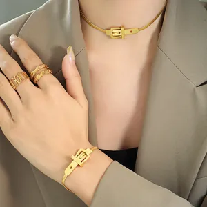Gold belt buckle choker necklace and bracelet jewelry set on chic blazer suit