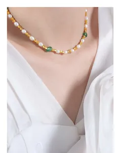 Dettaglio collana di perle naturali e perline d'oro con pietre di giada verde su donna