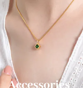 Close-up of a French retro gold necklace featuring a square emerald glass stone pendant