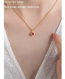 Elegant gold necklace with a square red gemstone pendant shown on a lace collar