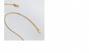 Detail of K18 hallmark on the lobster clasp and extension chain of gold plated necklace