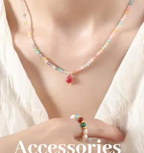 Detail of beaded necklace with red teardrop agate pendant and pearl accent ring
