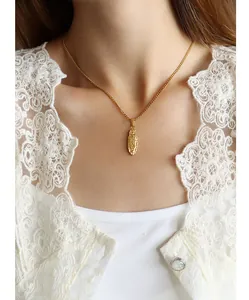 Detailaufnahme der goldenen Halskette mit ovalem Relief-Anhänger und eleganter Spitze