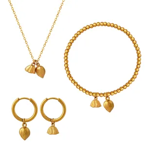 Matte gold jewelry set featuring lotus pod and flower bud pendants on a white background