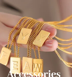 Macro detail of gold square letter pendants with vertical rectangular design and fine O-chains