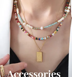 Primer plano de collares de perlas en capas con colgante de oro grabado en una modelo