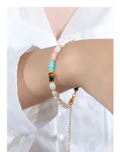 Gros plan d'un bracelet en perles multicolores avec œil de tigre et perles sur un poignet