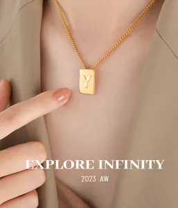 Detailed close-up of a polished gold-plated letter Y square pendant necklace on a model