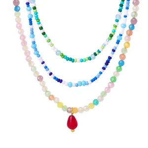 Three-layer bohemian beaded necklace with colorful faceted crystals and a red teardrop pendant